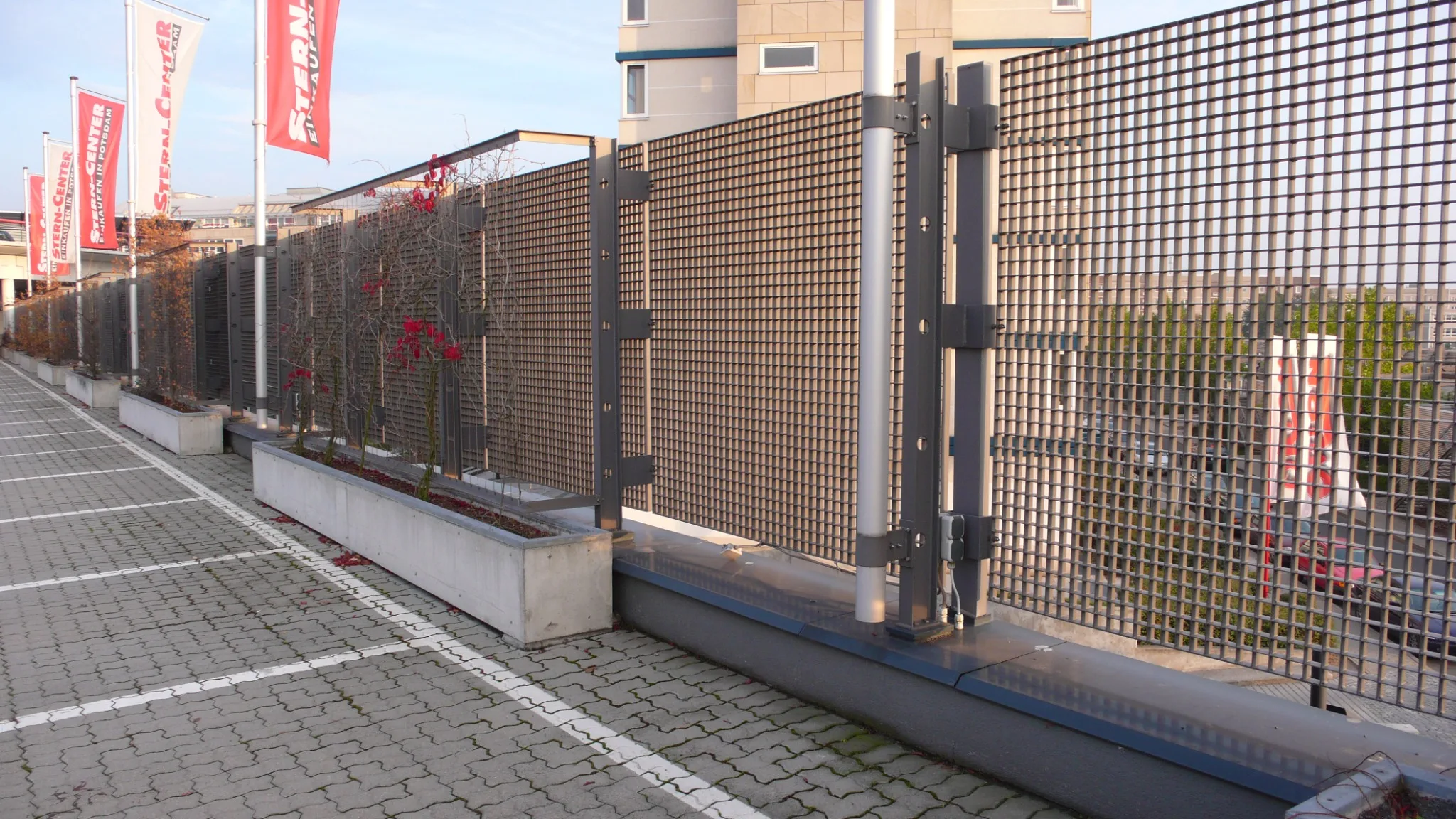 Gitterrostzaun mit beschichteten Zaunfeldern und integriertem Tor an einem Gewerbeobjekt